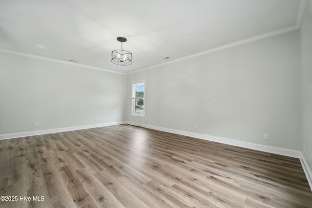 spare room with baseboards, an inviting chandelier, and wood finished floors