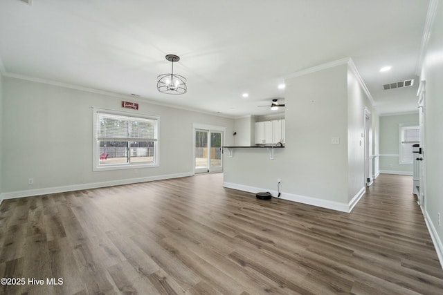 unfurnished living room with dark wood-style floors, visible vents, baseboards, recessed lighting, and crown molding