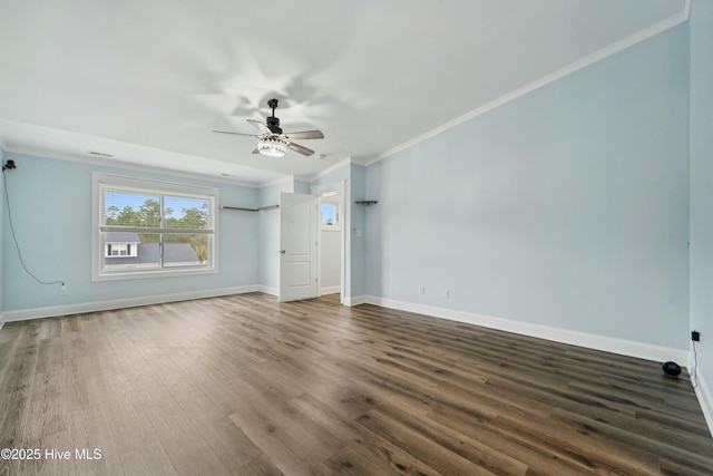 empty room featuring baseboards, dark wood-type flooring, ceiling fan, and crown molding