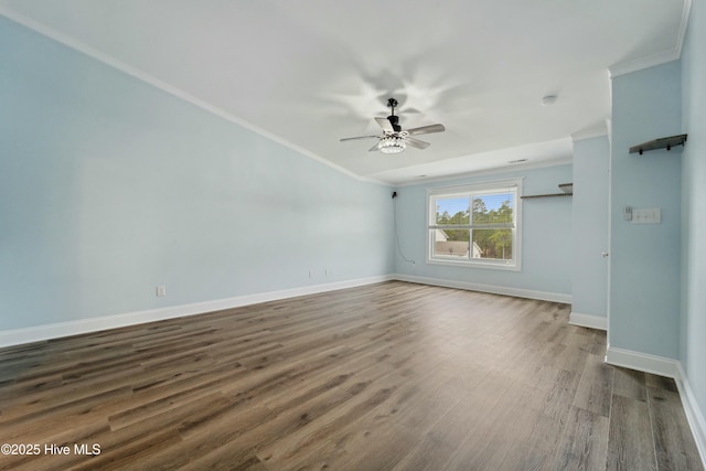 spare room with dark wood finished floors, baseboards, ceiling fan, and ornamental molding