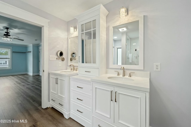 bathroom featuring double vanity, wood finished floors, ceiling fan, and a sink