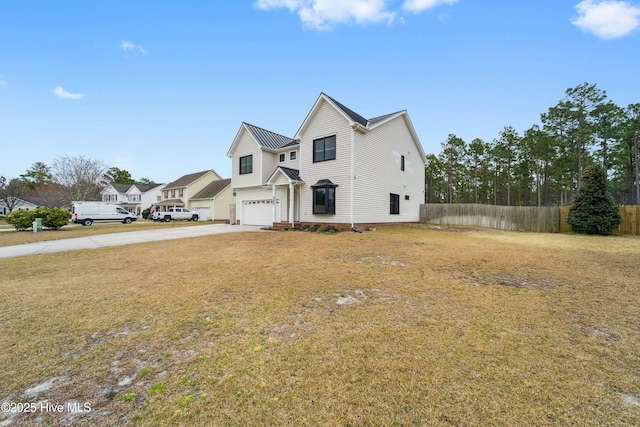 traditional-style house featuring concrete driveway, an attached garage, fence, and a front lawn