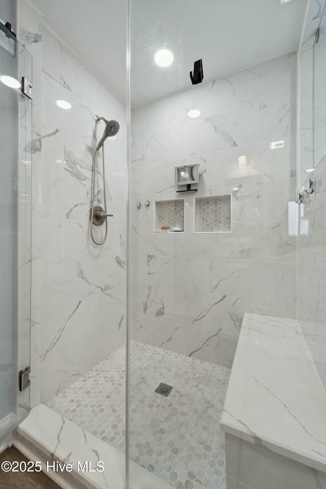 bathroom featuring a marble finish shower