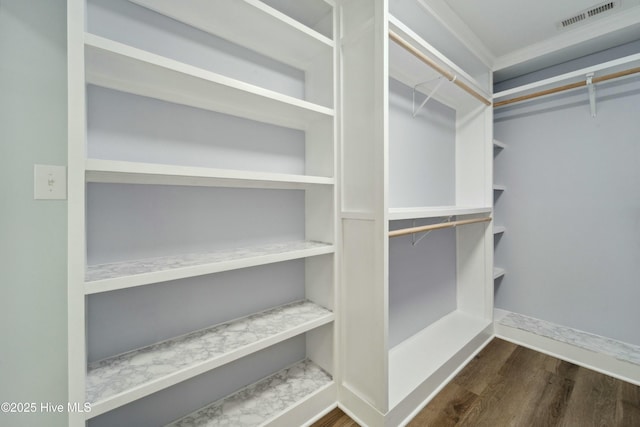 spacious closet featuring wood finished floors and visible vents