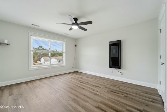 unfurnished room featuring visible vents, baseboards, ceiling fan, and wood finished floors