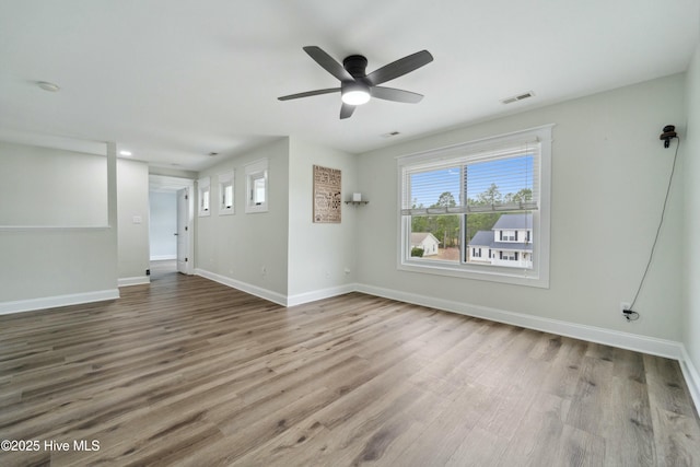 unfurnished living room with visible vents, ceiling fan, baseboards, and wood finished floors