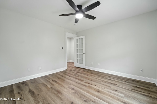 spare room featuring wood finished floors, baseboards, and ceiling fan