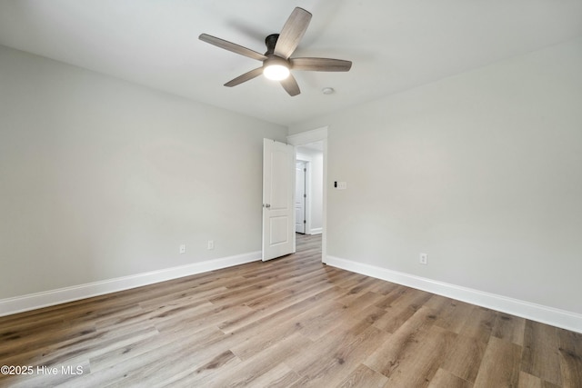 empty room featuring ceiling fan, baseboards, and wood finished floors