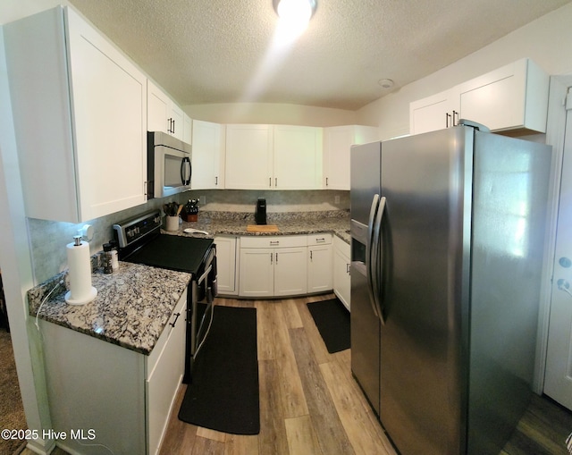 3206 Deer Path Cir, New Bern, NC 28560 - kitchen with appliances with stainless steel finishes, light wood-style flooring, white cabinetry, light stone countertops, and a textured ceiling