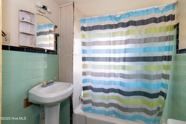 bathroom with tile walls and shower / bathtub combination with curtain