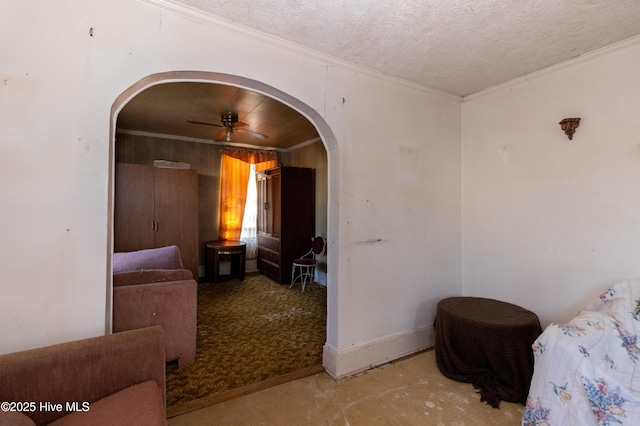 bedroom with baseboards, arched walkways, a textured ceiling, and crown molding