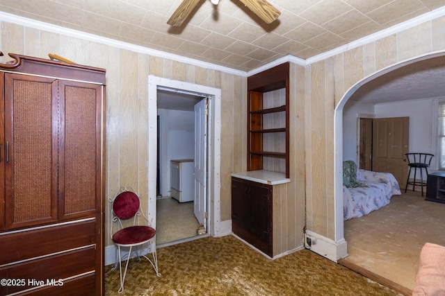 bedroom with arched walkways, wooden walls, and crown molding