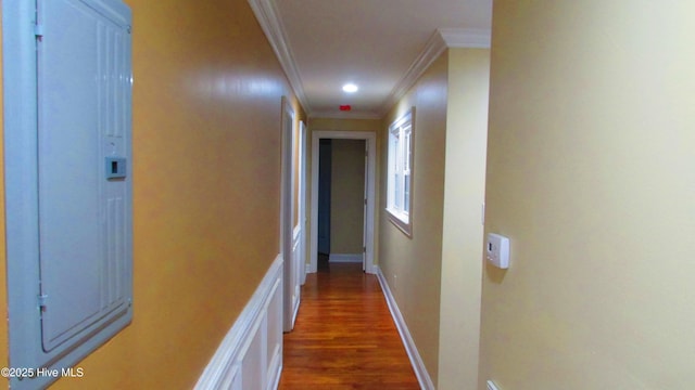 corridor featuring crown molding, wood finished floors, and baseboards