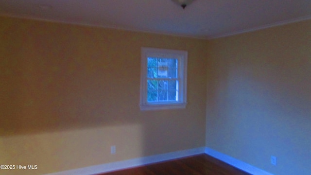 empty room featuring baseboards and dark wood-style flooring