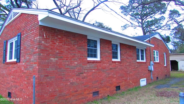 view of side of property with crawl space and brick siding