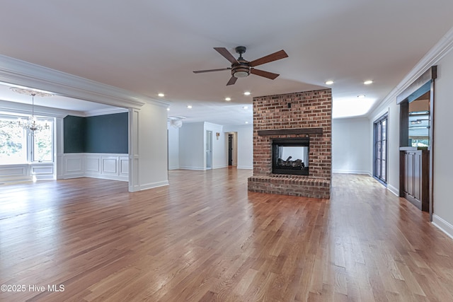 240 Donald Ross Dr, Pinehurst, NC 28374 - unfurnished living room featuring ornamental molding, a chandelier, ceiling fan, a fireplace, and light wood-style flooring