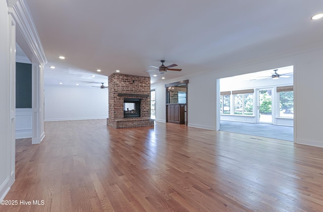 240 Donald Ross Dr, Pinehurst, NC 28374 - unfurnished living room with ceiling fan, crown molding, wood finished floors, a brick fireplace, and baseboards