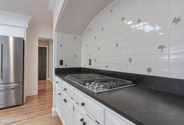 240 Donald Ross Dr, Pinehurst, NC 28374 - kitchen featuring stainless steel appliances, dark countertops, white cabinets, light wood finished floors, and backsplash