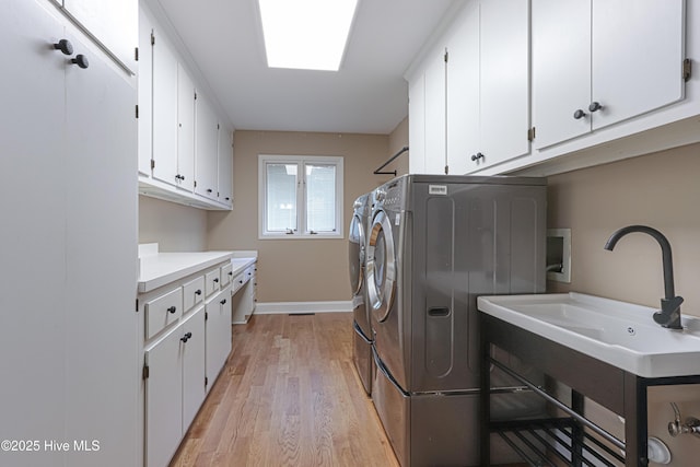 240 Donald Ross Dr, Pinehurst, NC 28374 - laundry area featuring cabinet space, independent washer and dryer, light wood-style flooring, and baseboards