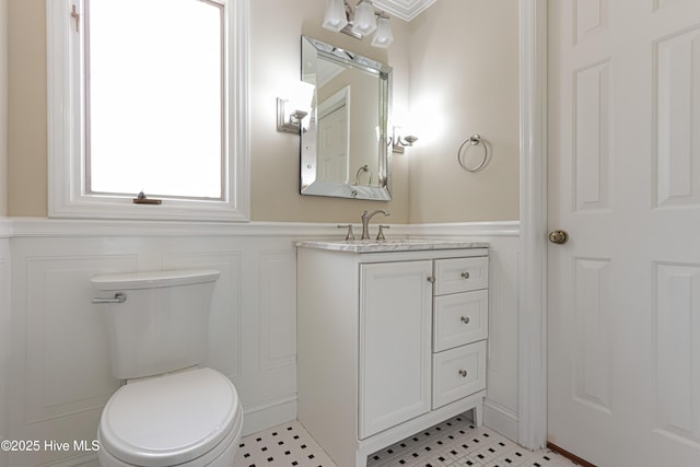 240 Donald Ross Dr, Pinehurst, NC 28374 - bathroom featuring a decorative wall, wainscoting, toilet, vanity, and tile patterned flooring