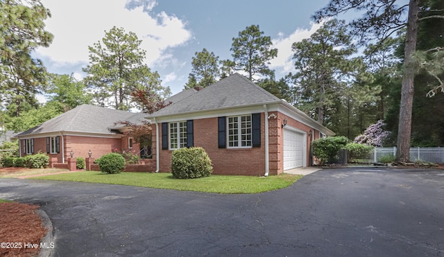 240 Donald Ross Dr, Pinehurst, NC 28374 - view of front of house with asphalt driveway, brick siding, fence, a garage, and roof with shingles