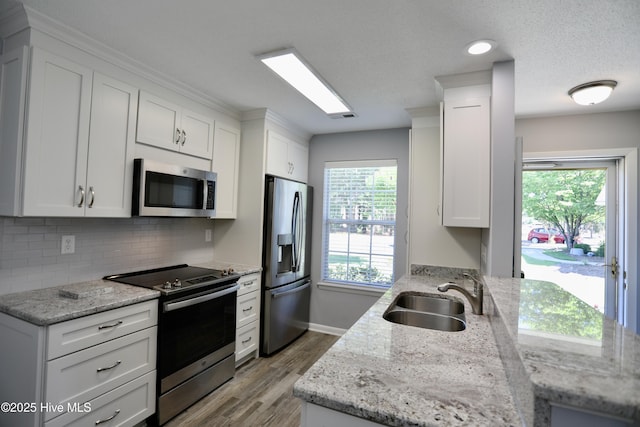 717 Chancery Ln, Aberdeen, NC 28315 - kitchen featuring stainless steel appliances, a sink, wood finished floors, and white cabinets
