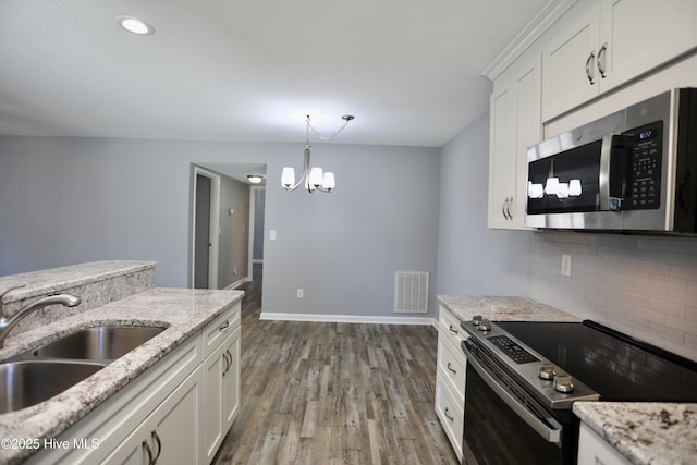 717 Chancery Ln, Aberdeen, NC 28315 - kitchen with appliances with stainless steel finishes, a sink, a chandelier, tasteful backsplash, and wood finished floors