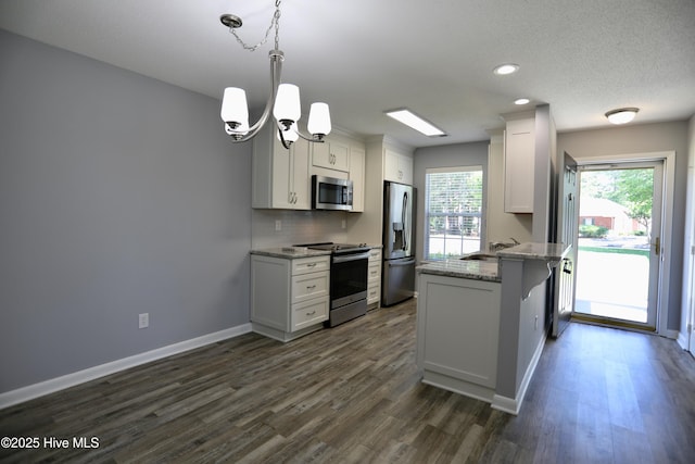 717 Chancery Ln, Aberdeen, NC 28315 - kitchen featuring appliances with stainless steel finishes, a peninsula, a chandelier, dark wood-style flooring, and recessed lighting