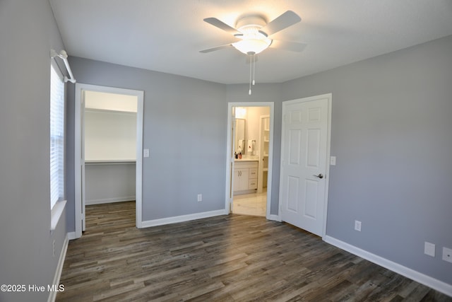 717 Chancery Ln, Aberdeen, NC 28315 - unfurnished bedroom featuring a walk in closet, dark wood-style floors, baseboards, and a closet