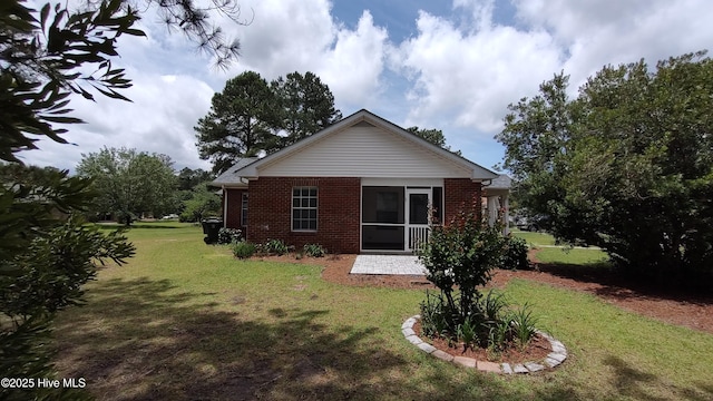 717 Chancery Ln, Aberdeen, NC 28315 - rear view of house with brick siding, a lawn, a patio area, and a sunroom