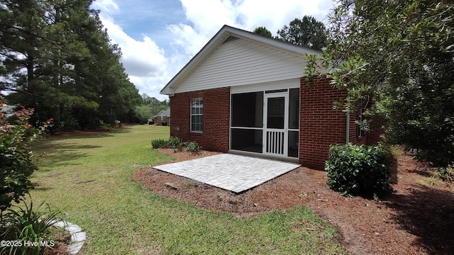 717 Chancery Ln, Aberdeen, NC 28315 - back of property featuring brick siding, a patio, and a lawn