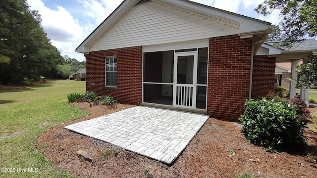 717 Chancery Ln, Aberdeen, NC 28315 - back of house with brick siding, a patio, a lawn, and a sunroom