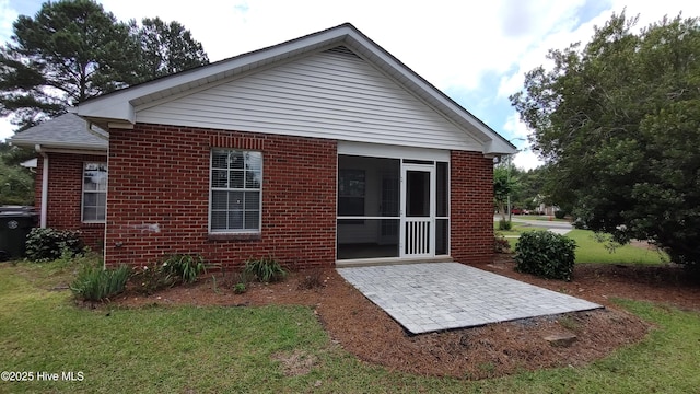 717 Chancery Ln, Aberdeen, NC 28315 - back of house with brick siding, a patio area, a sunroom, and a lawn
