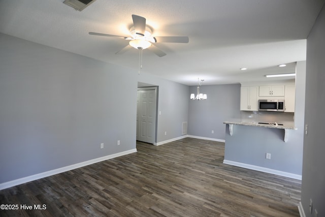 717 Chancery Ln, Aberdeen, NC 28315 - unfurnished living room featuring a chandelier, a ceiling fan, baseboards, dark wood-style floors, and recessed lighting