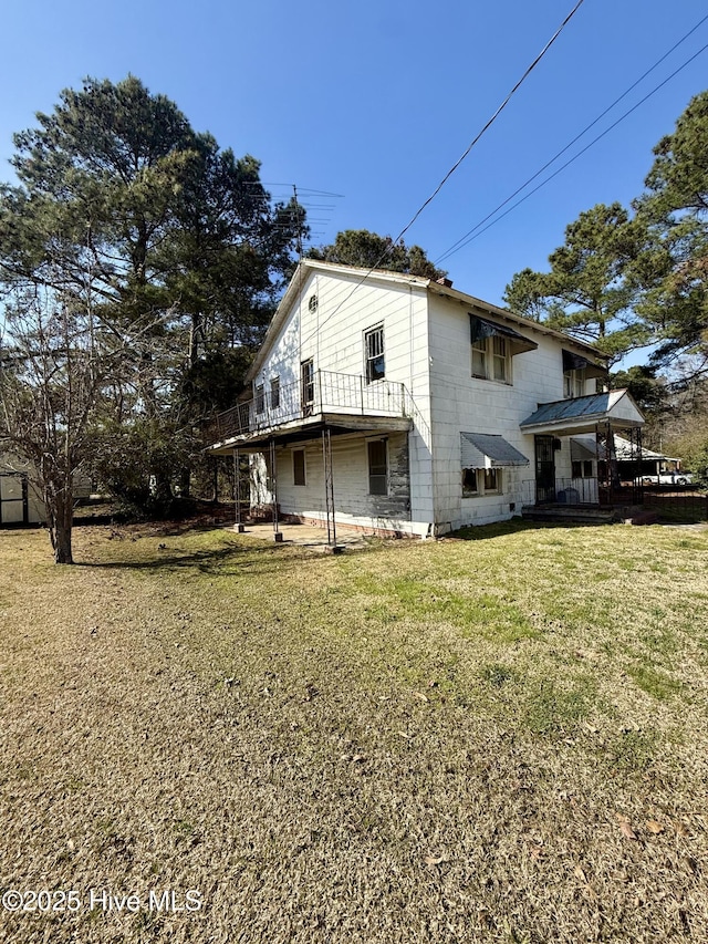 rear view of property featuring a lawn