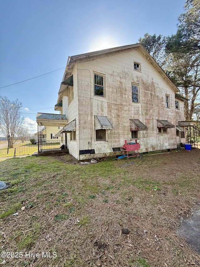 rear view of house with a lawn and fence