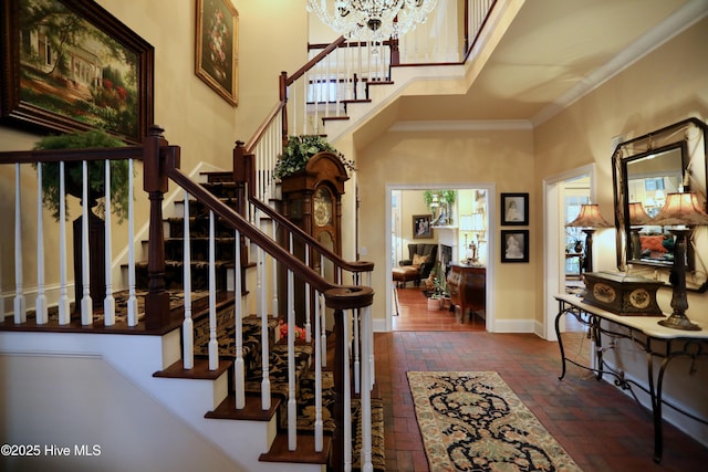 6680 Beulah Hill Church Rd, West End, NC 27376 - stairs with brick floors, ornamental molding, a chandelier, and a high ceiling