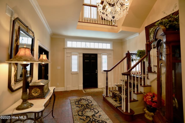 6680 Beulah Hill Church Rd, West End, NC 27376 - foyer entrance with a chandelier, crown molding, stairs, a towering ceiling, and brick floors
