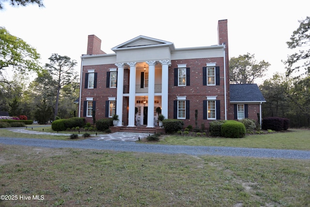 6680 Beulah Hill Church Rd, West End, NC 27376 - greek revival inspired property featuring a balcony, a chimney, a front lawn, and brick siding