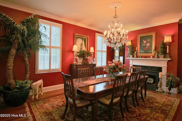 6680 Beulah Hill Church Rd, West End, NC 27376 - dining space featuring wood finished floors, a chandelier, crown molding, and a fireplace