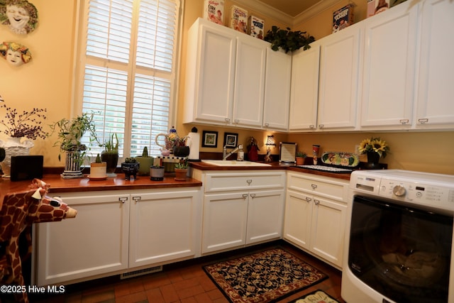 6680 Beulah Hill Church Rd, West End, NC 27376 - kitchen with washer / clothes dryer, ornamental molding, white cabinetry, and butcher block counters