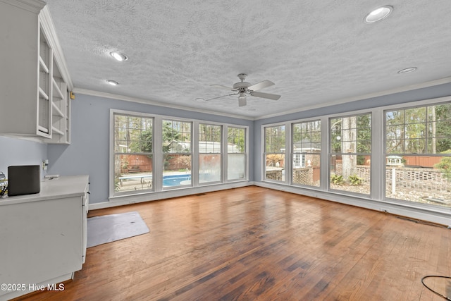 interior space featuring a textured ceiling, crown molding, a ceiling fan, and hardwood / wood-style flooring