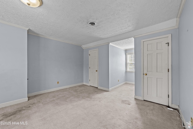 unfurnished room with crown molding, baseboards, visible vents, and light carpet