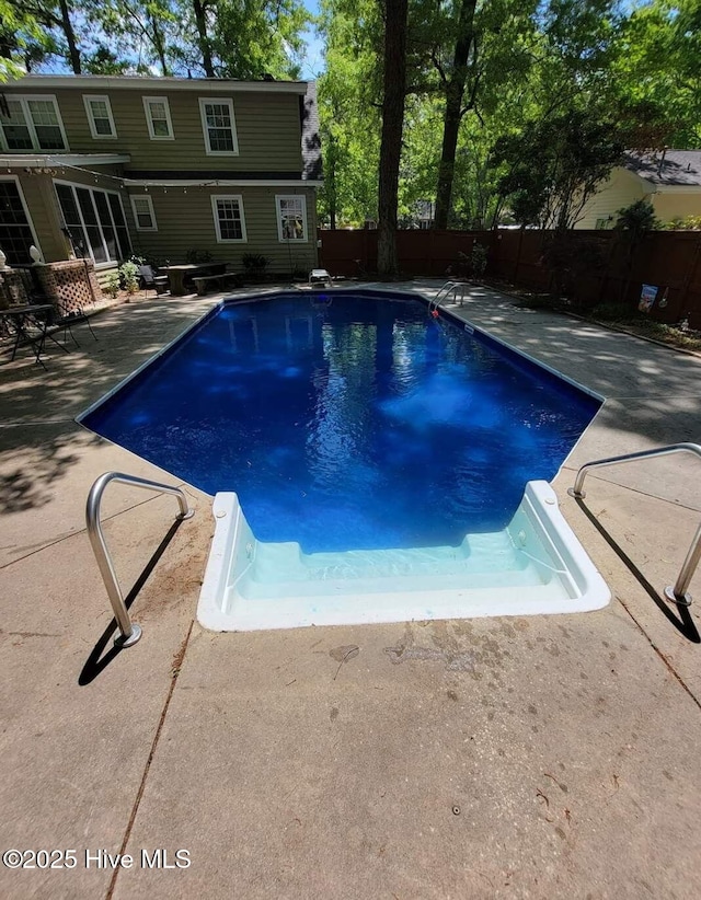 view of pool with a fenced in pool, fence, and a patio area