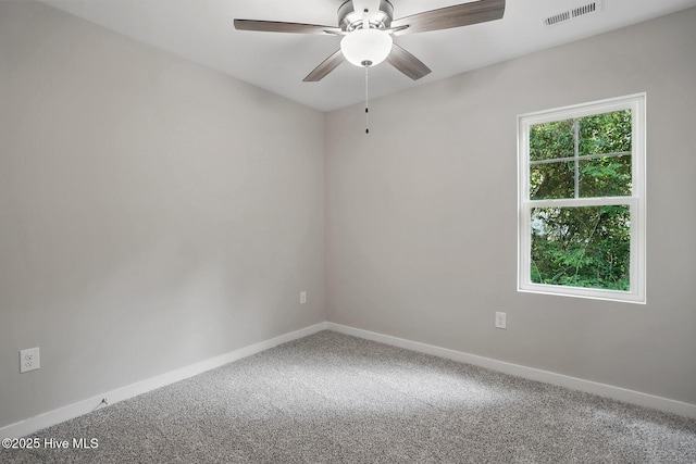 carpeted empty room featuring a ceiling fan and baseboards