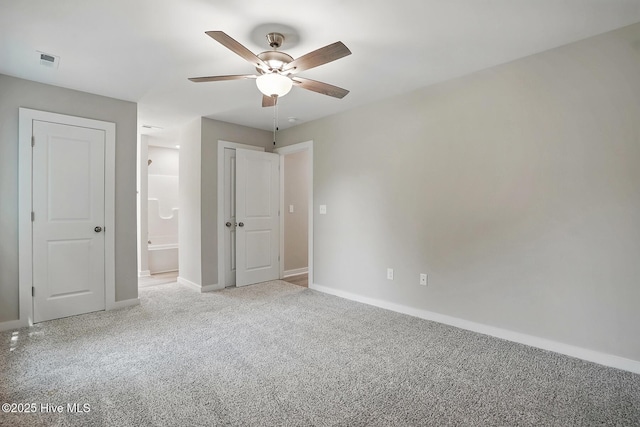 unfurnished bedroom with carpet flooring, baseboards, ensuite bath, and ceiling fan