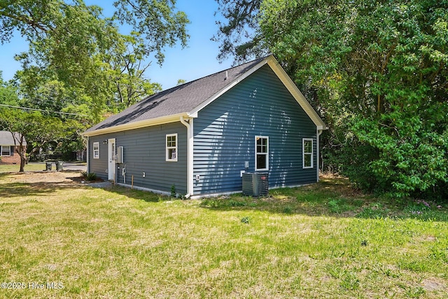 view of property exterior with central AC unit and a yard