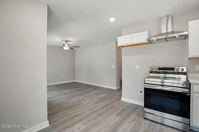 kitchen featuring stainless steel electric range oven, wall chimney exhaust hood, a ceiling fan, baseboards, and recessed lighting