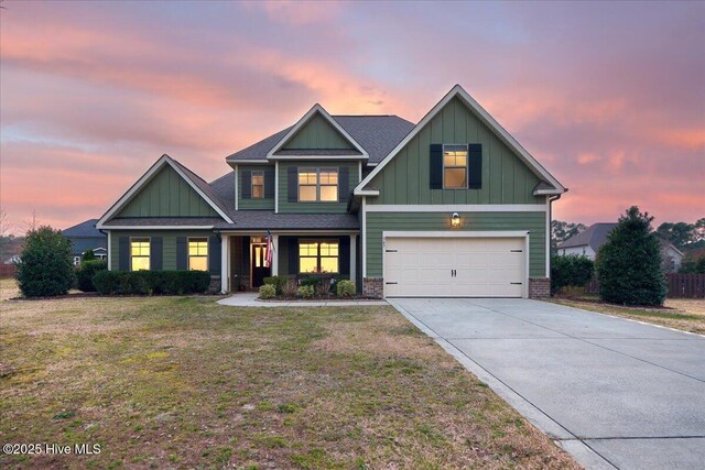 craftsman-style home featuring driveway, a yard, a garage, board and batten siding, and brick siding