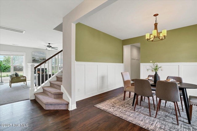 dining space with stairway, visible vents, dark wood finished floors, and wainscoting